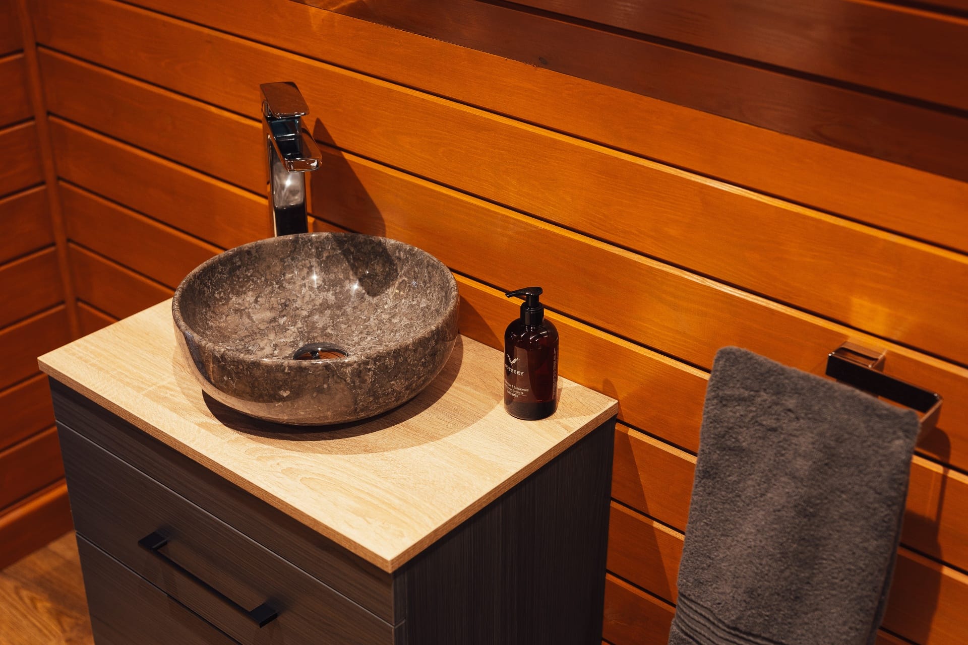 Stone basin on a timber vanity with natural shower gel