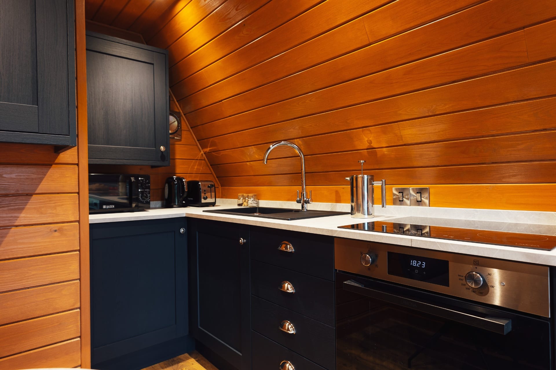 Induction hob, oven and stone sink in the cabin's compact kitchen
