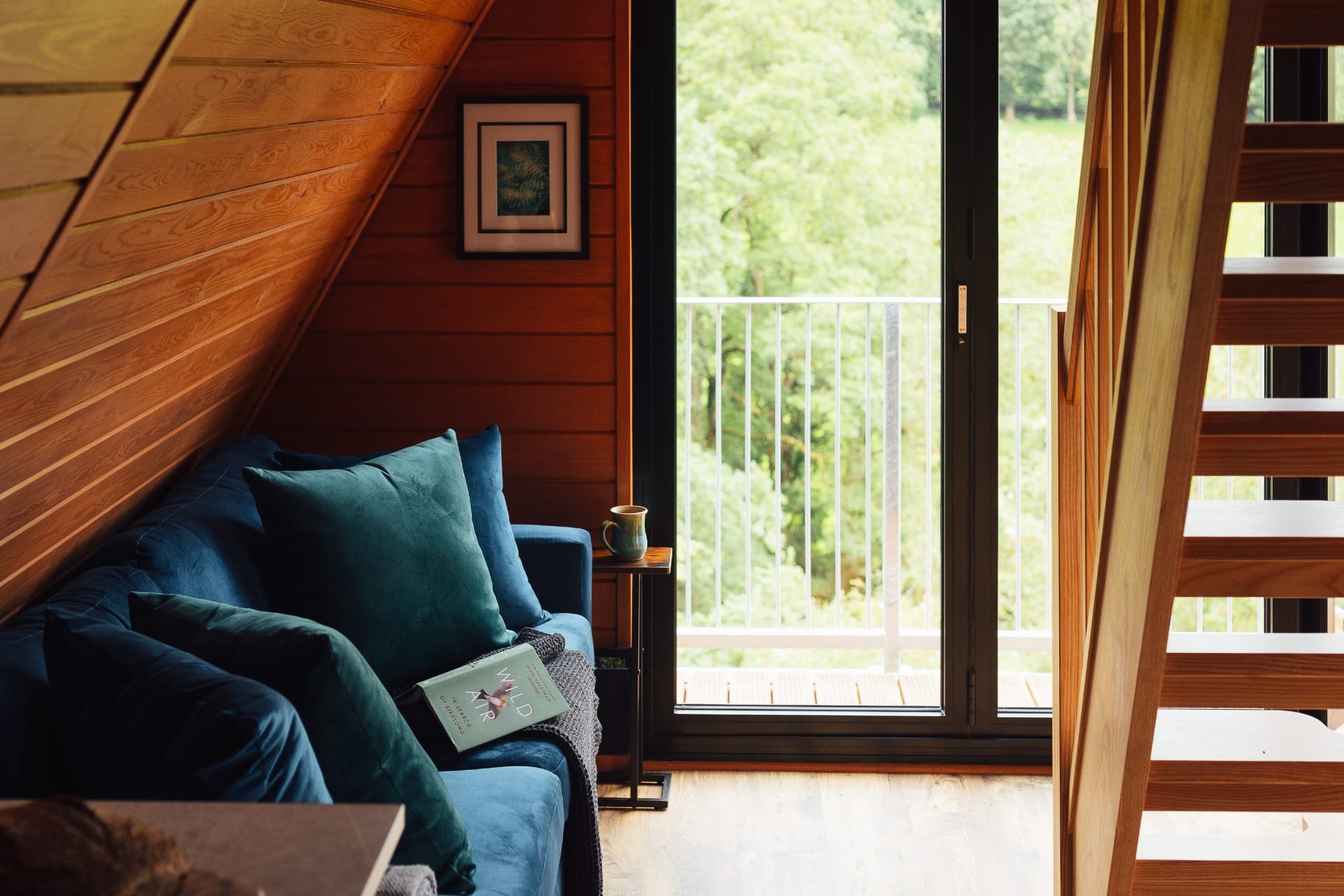 Velvet sofa by the bifold doors with a view of the woodland at The Perch