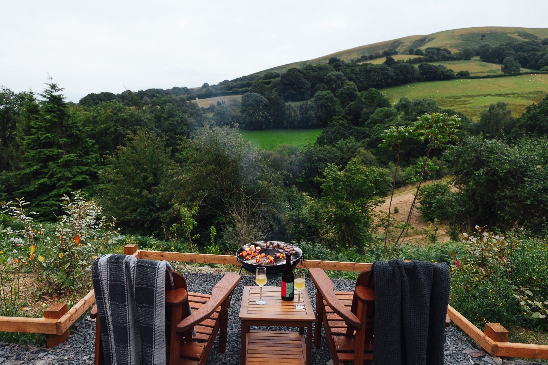 The Perch deck and hot tub overlooking the Welsh valley at dusk
